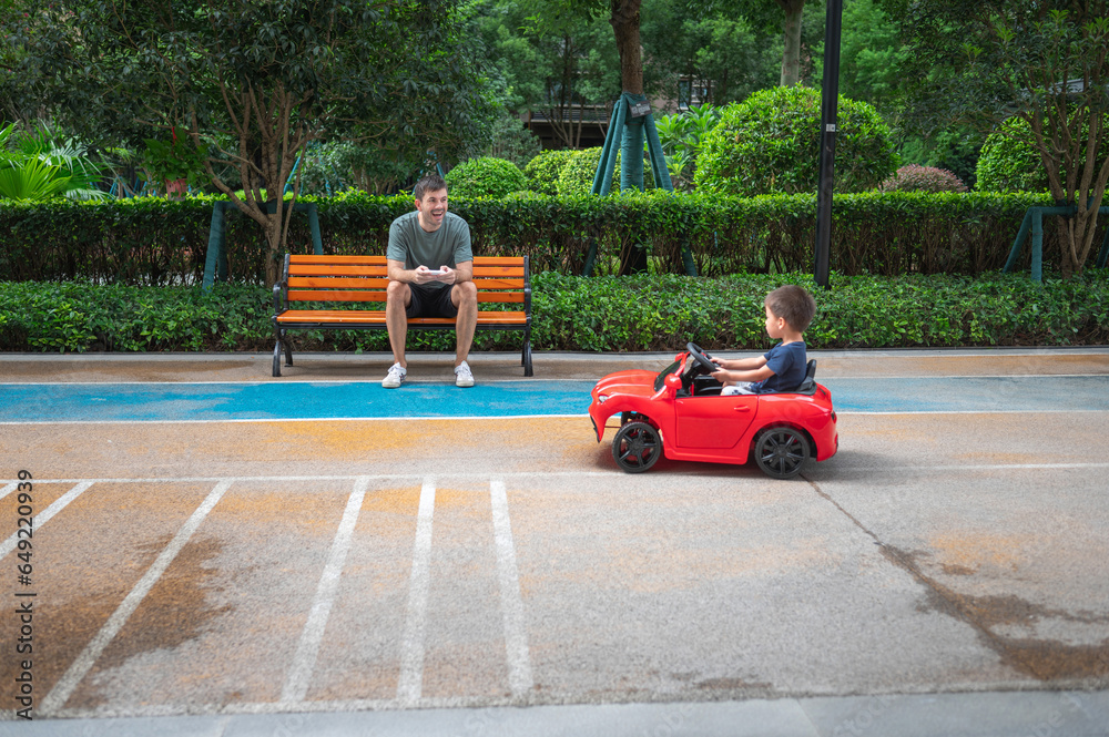 Little boy is riding in a remote controlled car