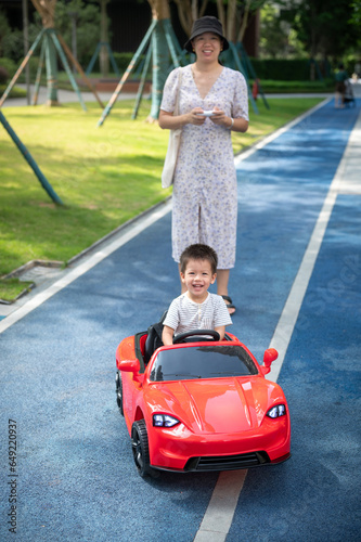Little boy is riding in a remote controlled car
