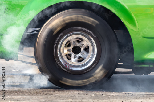 Close up car wheel with smoke on the asphalt road speed track, Car wheel drifting and smoking on track, Car wheel spinning. © Darunrat