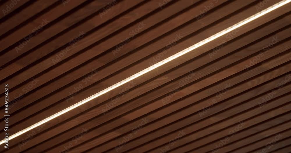 Ceiling with wooden planks and led light lamp at house. Decorative wood panels in interior of modern apartment