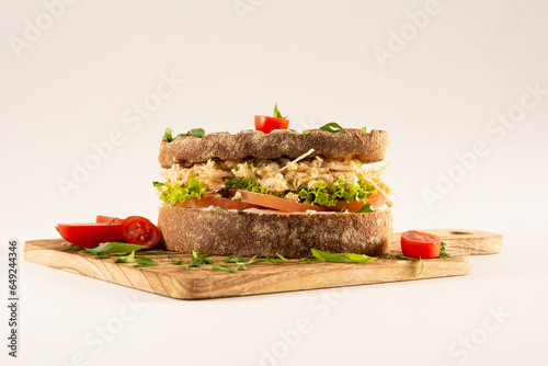 Foto Chicken Breast Sandwich on Whole Grain Bread with Fresh Salad in a Wooden Table