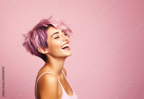 Woman with short sassy purple color hair, laughing away. On pink background, copy space. photo