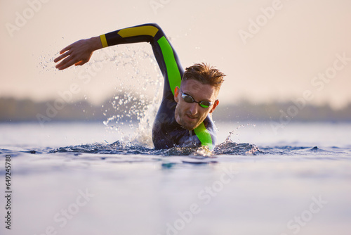 Konstfotografi Motivated and concentrated man, professional sportsman swimming into river, training session