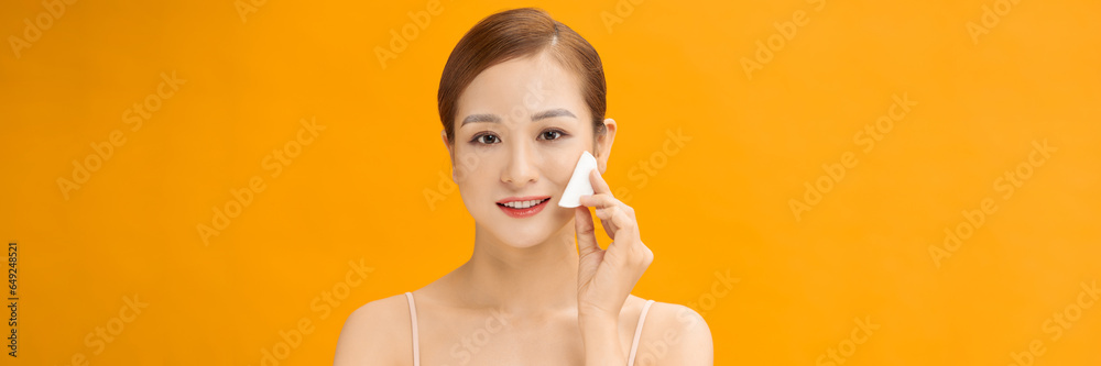 Woman Using Cotton Pad Cleansing Face Over banner yellow Background Woman Using Cotton Pad Cleansing Face Over banner yellow Background