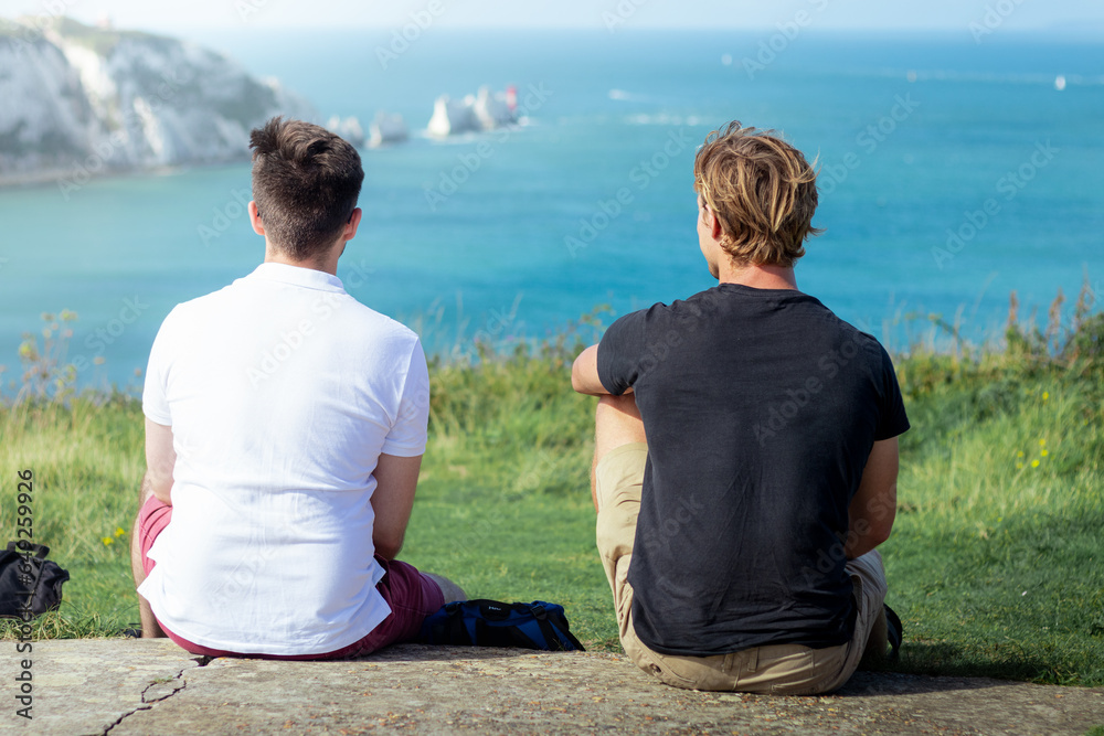 Two men sit and enjoy the sea views