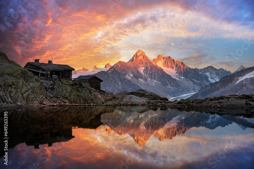 Fototapeta Naklejka Na Ścianę i Meble -  Wooden cabin on Lac Blanc lake in French Alps during incredible sunset. Monte Bianco mountains range on background. Landscape photography