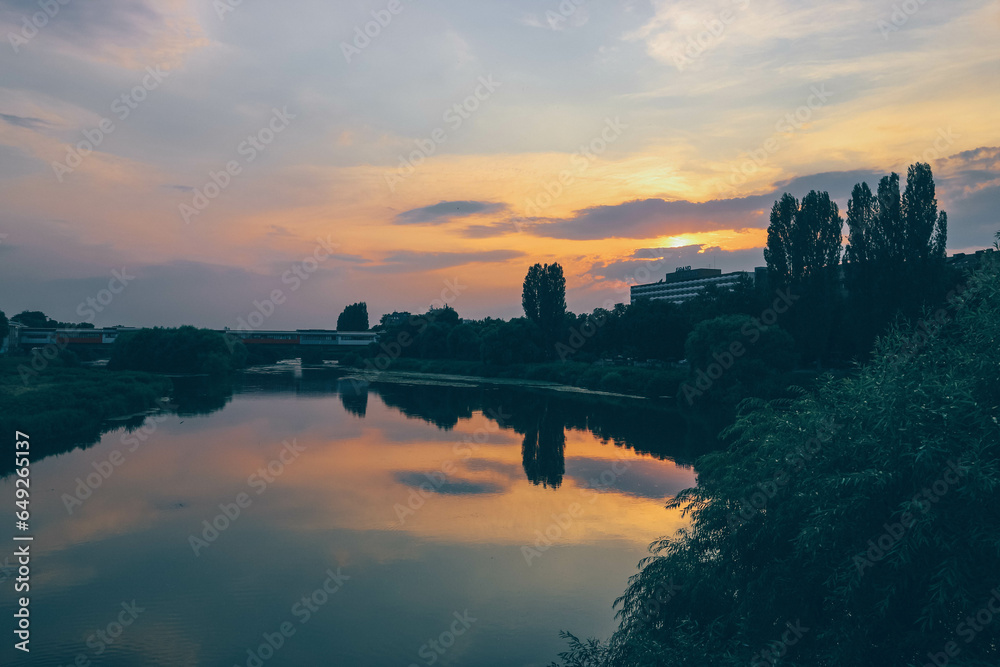 view of sunset by the river in bulgarian town with untouched vegetation 