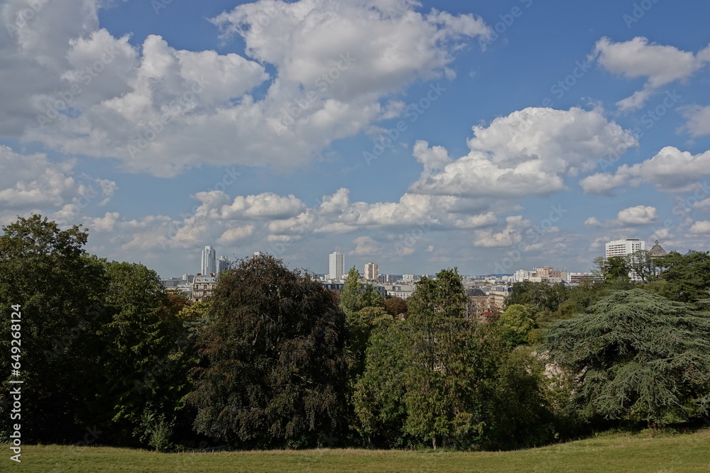 Vue du parc des Buttes-Chaumont sur Paris avec ciel bleu et gros nuages blancs 