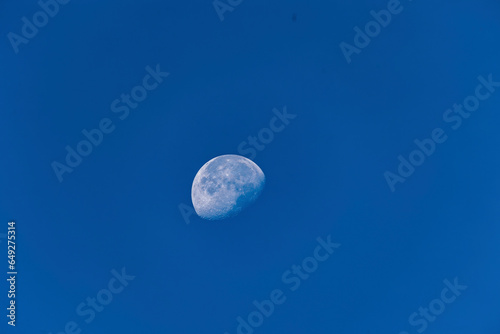 Waning moon in daylight and blue sky