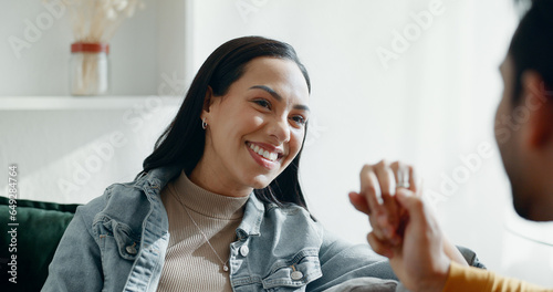 Couple, kiss on hand and talking on home sofa with smile, security and love in healthy relationship. Young man and woman together in living room for affection, funny laugh and communication with care