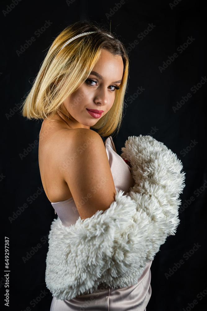 woman in a fur coat and a dress is photographed in a fashion studio isolated. woman in a fur coat and a dress is photographed in a fashion studio isolated.