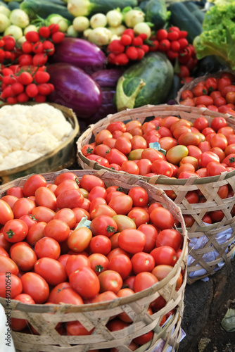 Vertical photo banner with various fresh vegetables at an organic farmers market in Southeast Asia. Organic vegetables and fruits at an Asian street market. Vegetables in wicker baskets.