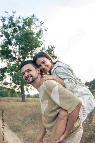 Playful and youthful adult man and woman having fun together in the meadow.
