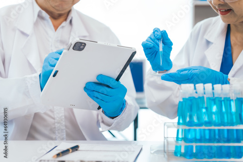 Senior scientists analyzing pharmaceuticals  asian people  senior man and woman  experienced experts in science  conducting pharmaceutical research in modern lab setting with powerful microscope.