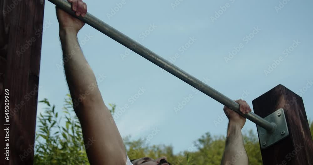 Sporty man doing pull-ups exercise  in slow-motion.