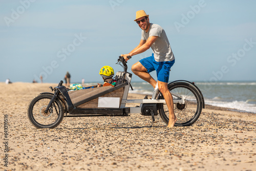 Papa und Kind haben Spaß mit dem Lastenrad am Strand,Skagen,Dänemark