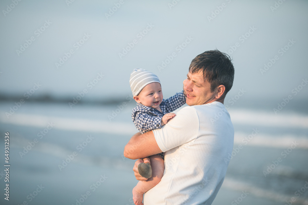 Happy Fathers day. Father and baby play on the beach. Dad and him Child together enjoying sunset. Loving single father hugs cute little son. Happy Fathers day. Father and baby play on the beach. Dad and him Child together enjoying sunset. Loving single father hugs cute little son.