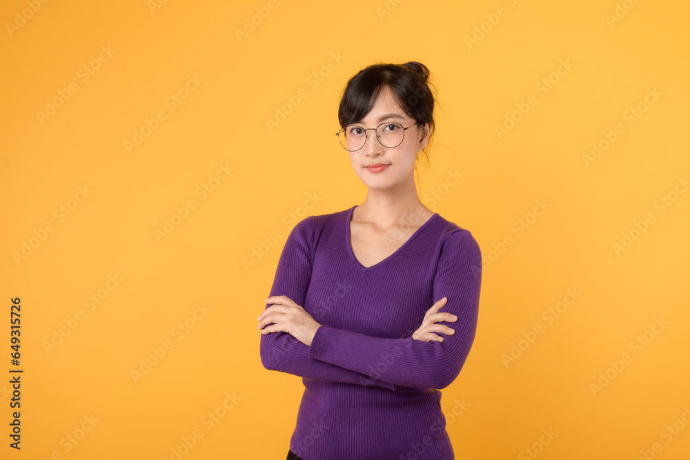 Obraz premium Lifestyle, people emotions and casual concept. Confident nice smiling young 30s asian woman cross arms chest confident, listening to coworkers, taking part conversation isolated on yellow background.