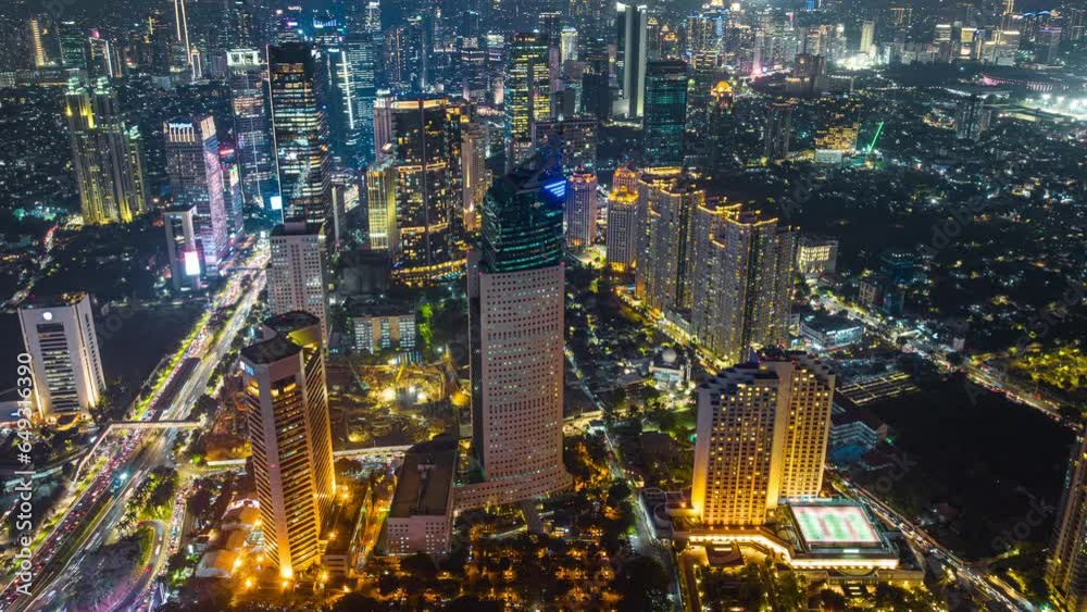 Night aerial view of skyscrapers and multi lane highway in large urban city center Cityscape of high rise buildings in Jakarta, Indonesia at night 
