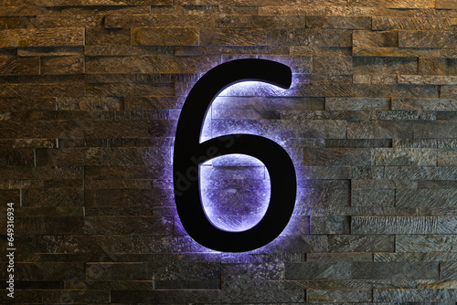 Dark Neon Font with fluorescent purple tubes Number 6 on the dark brown brick wall. Night Show Alphabet.