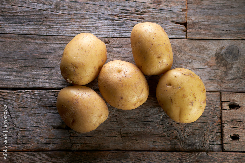 Fresh raw potatoes on wooden background Fresh raw potatoes on wooden background