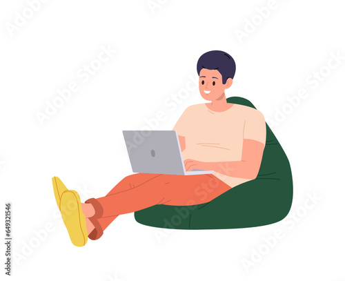 Young man freelancer or student sitting on soft bean bag with laptop computer isolated on white