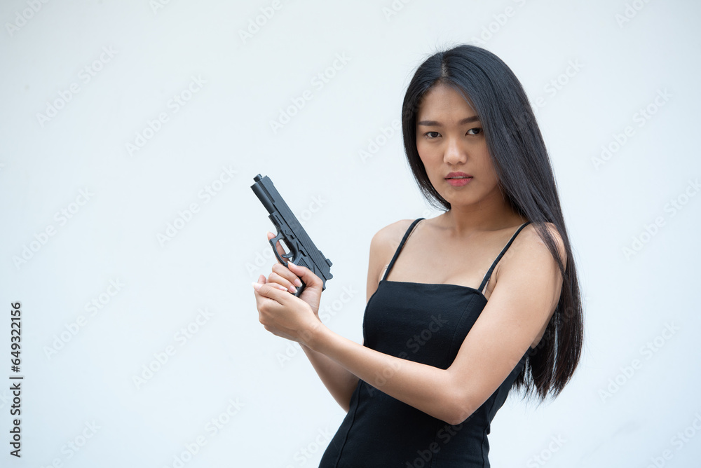 Sexy beauty young woman in black camisole posing with gun on white background. Girl in camisole with gun hand sexy brunette woman gun plain background. Sexy beauty young woman in black camisole posing with gun on white background. Girl in camisole with gun hand sexy brunette woman gun plain background.