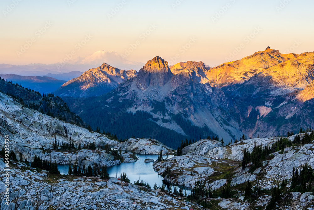 First morning light on mountain range seen from Robin lake in Central Cascades