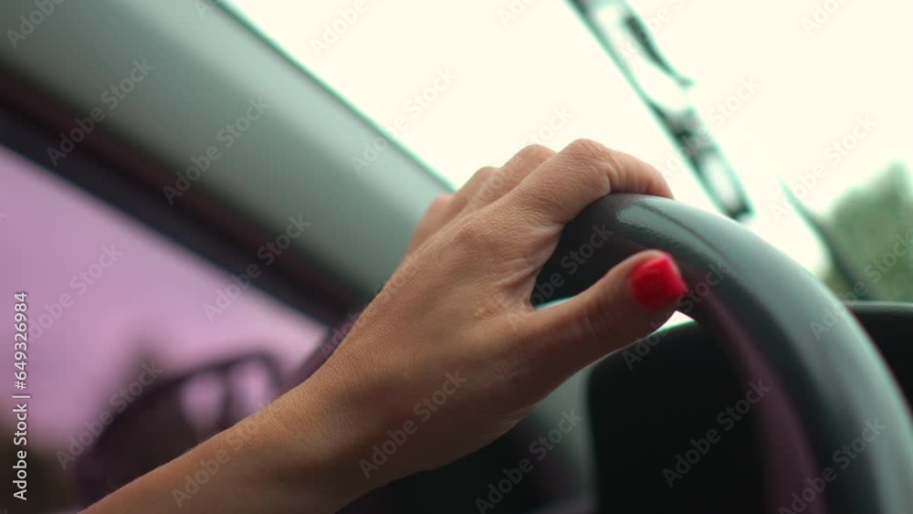 Side view of woman hands on steering wheel driving vehicle on road. Adult girl having safety ride to job in vehicle Side view of woman hands on steering wheel driving vehicle on road. Adult girl having safety ride to job in vehicle