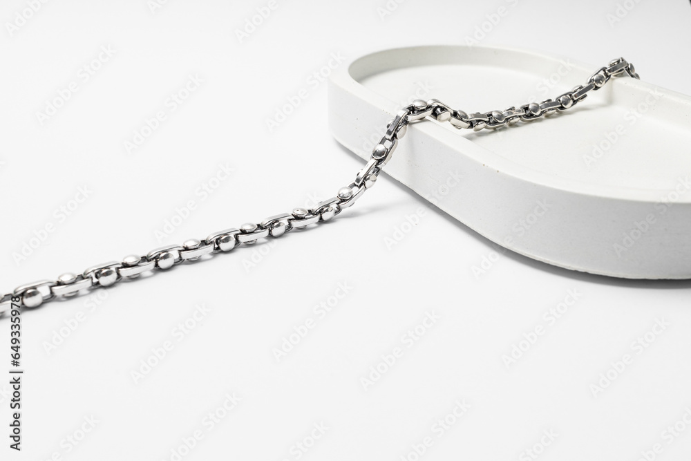 Silver chain on white plaster stand, subject macrophotography Silver chain on white plaster stand, subject macrophotography