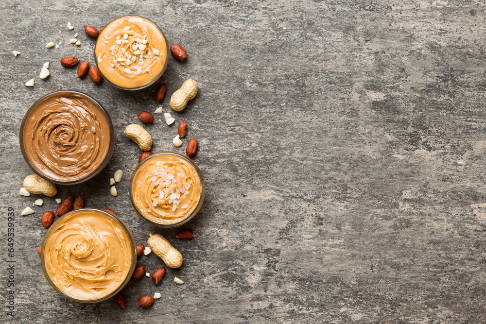 Glass jar with peanut butter on table background, top view space for text and close up