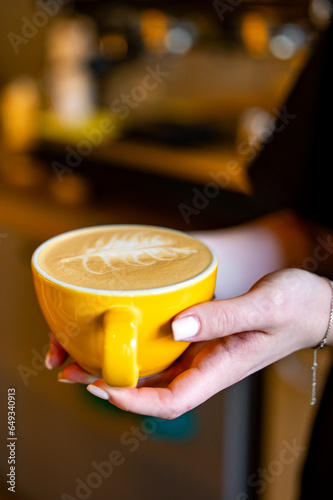 Woman barista hands holding cup of hot coffee latte cappuccino