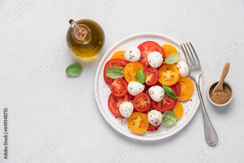 Appetizing Italian caprese salad. Tomatoes mozzarella basil salad close-up view on white background