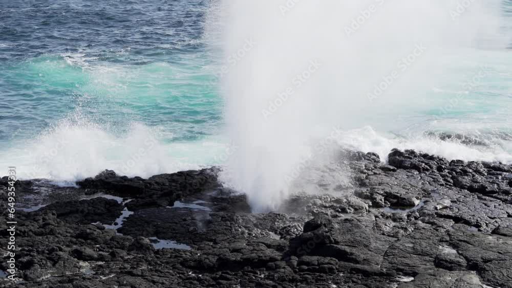 sea water of the pacific ocean being pressed through a blow hole and emitting salt water spray at the lava rock beach of the Galapagos islands. sea water of the pacific ocean being pressed through a blow hole and emitting salt water spray at the lava rock beach of the Galapagos islands.