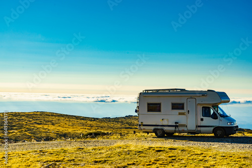 Camper on mountain peak above clouds, Portugal.