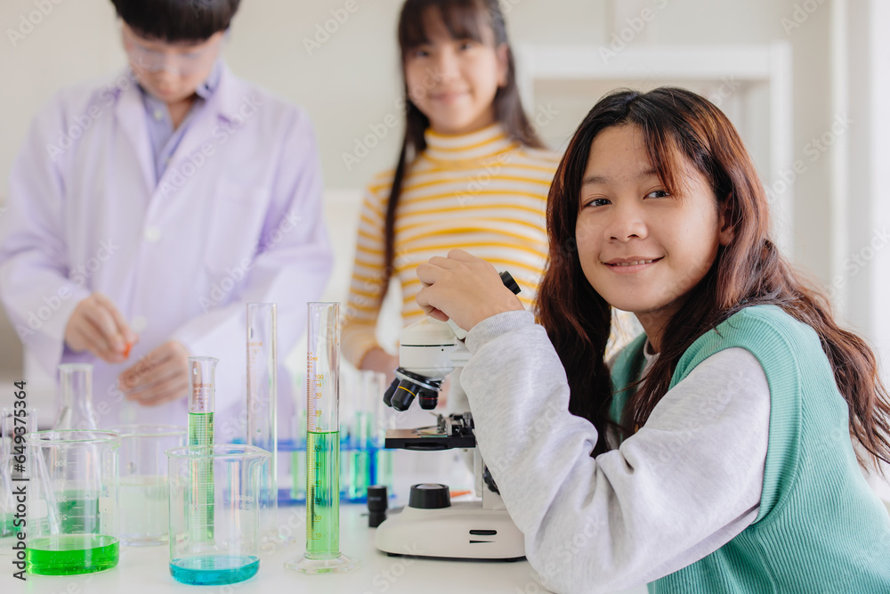 Portrait smart young asian teen girl enjoy learning and play in school experimental chemical science lab happy smiling Portrait smart young asian teen girl enjoy learning and play in school experimental chemical science lab happy smiling