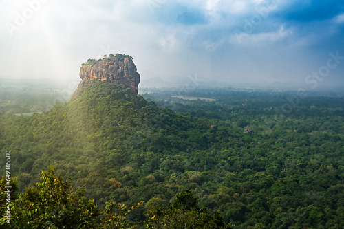 Pidurangala Ancient Forest Monastery, Sigiriya, Sri Lanka - View of sigirya rock at sunset jungle and tropical scenary in a cloudy sky photo