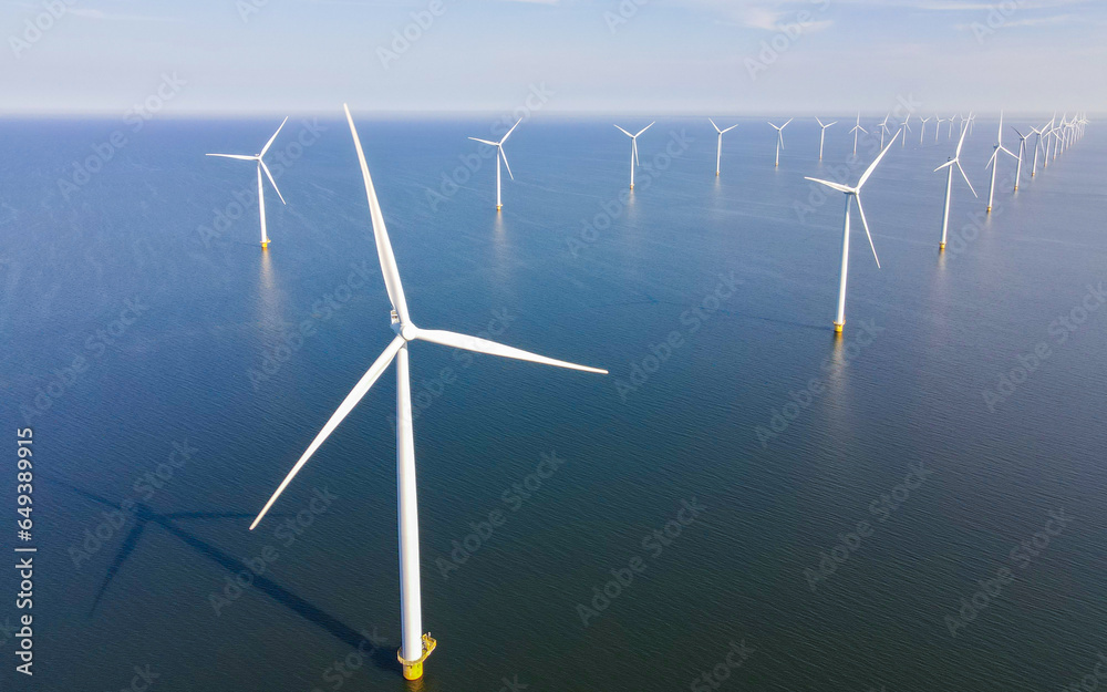 Huge windmill turbines, Offshore Windmill farm in the ocean Westermeerwind park , windmills isolated at sea on a beautiful bright day Netherlands Flevoland Noordoostpolder Huge windmill turbines, Offshore Windmill farm in the ocean Westermeerwind park , windmills isolated at sea on a beautiful bright day Netherlands Flevoland Noordoostpolder