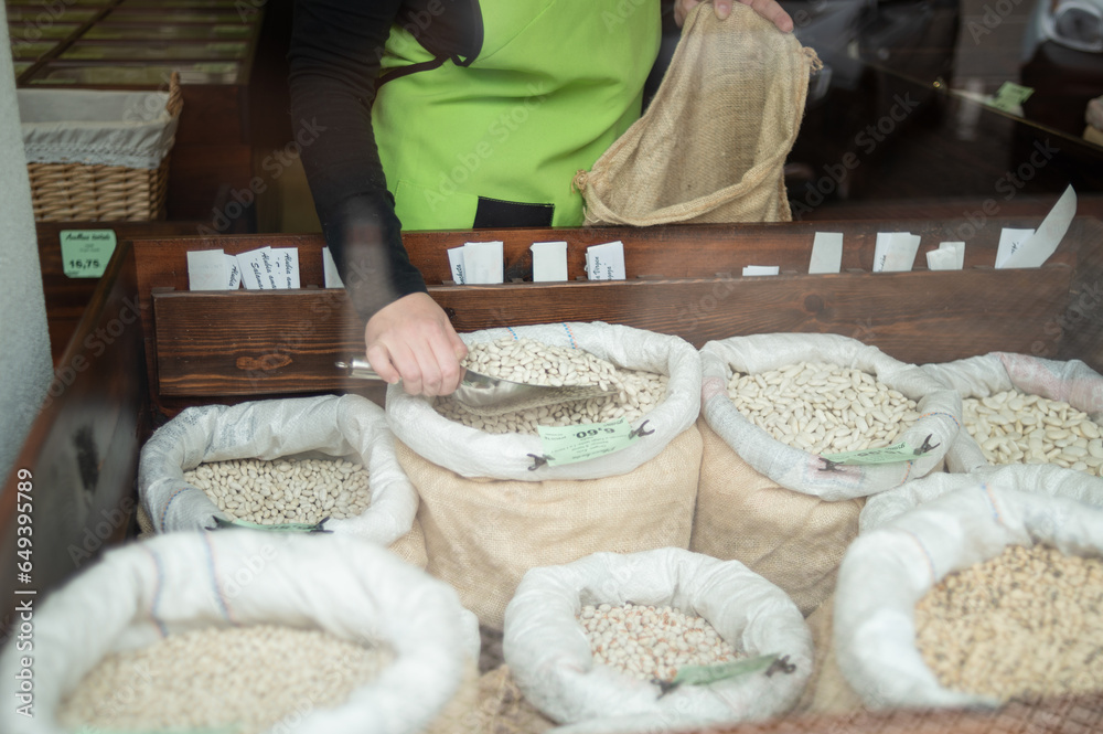 © Gonzalo Infiesta - Unrecognizable woman choosing grains with scoop in shop