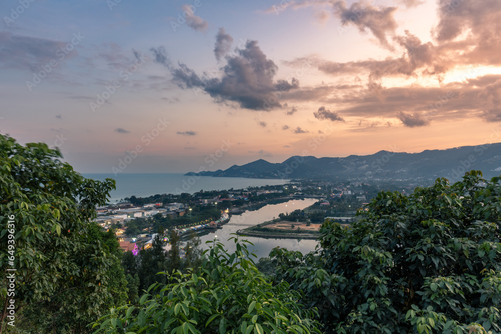 Panorama of town, tropical coastline, dense rain forest from high hill at sunset, Koh Samui, Thailand