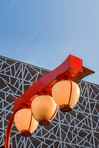 Liberdade neighborhood, São Paulo, Brazil. Suzuran. Traditional public lighting in the Japanese Quarter. Modern building facade and blue sky in the background.