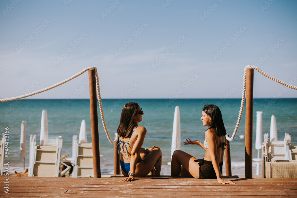 Smiling young women in bikini enjoying vacation on the beach