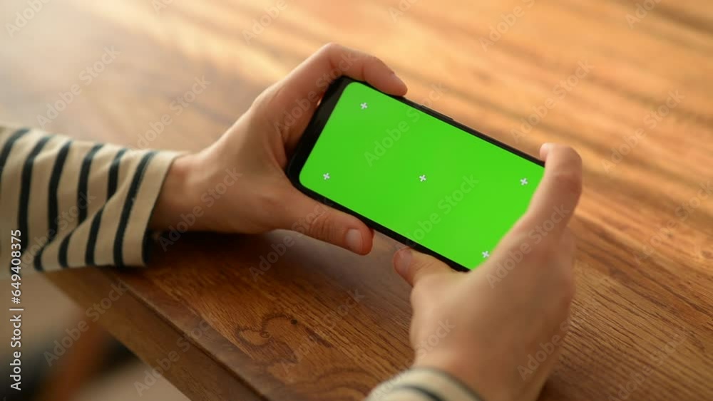 a woman using a green-screen smartphone in her home a woman using a green-screen smartphone in her home