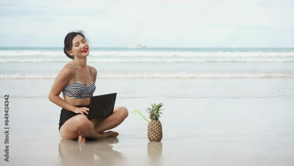 Woman freelancer works on the beach. Young asian female girl working with computer laptop on the tropical island beach with happy emotion. Technology for wherever concept. Distant self work concept.