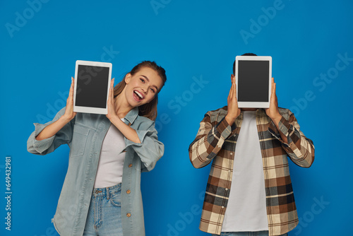 Cuadro en lienzo african american man obscuring face with digital tablet near excited woman on bl