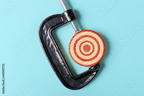Quadro su tela Target in C-clamp on blue background. Stay Focused on Your Goal