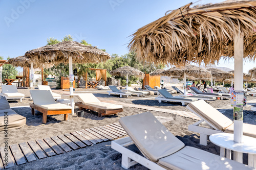 Fira, Greece - July 20, 2023: Palapas and beach chairs on the island of Santorini in Greece 