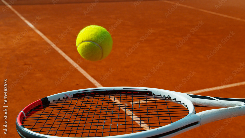 Bouncing tennis ball on tennis racket, clay court, freeze motion