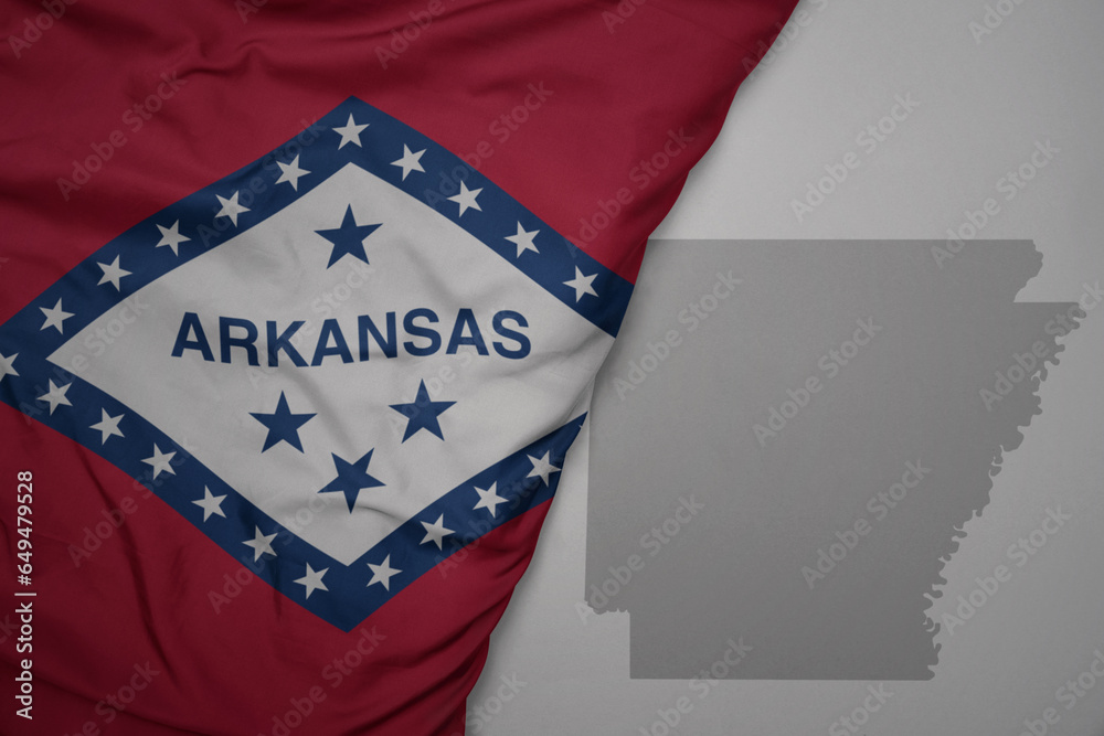 big waving national colorful flag and map of arkansas state on the gray background. big waving national colorful flag and map of arkansas state on the gray background.