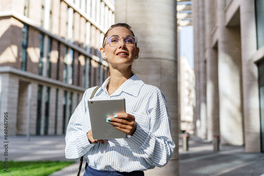 The administrator of the financier person responds to the client by email. A woman in a shirt in modern office clothes works online. A smart manager with glasses uses a tablet computer and a chat bot. The administrator of the financier person responds to the client by email. A woman in a shirt in modern office clothes works online. A smart manager with glasses uses a tablet computer and a chat bot.